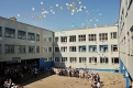 Во дворе благовещенской школы № 25 недавние ученики запустили в небо гелевые шары.