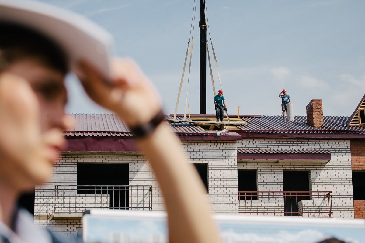 Рабочие заканчивают обустройство кровли на нескольких домах.