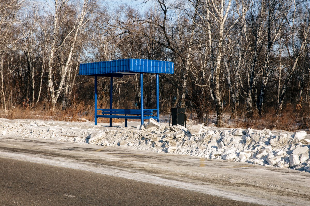 Многие остановки в городе находятся в окружении сугробов.
