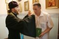 Отец Олег освящает награды для десантников.